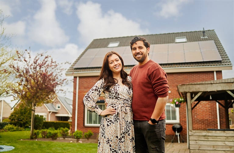 Man en vrouw voor huis met zonnepanelen