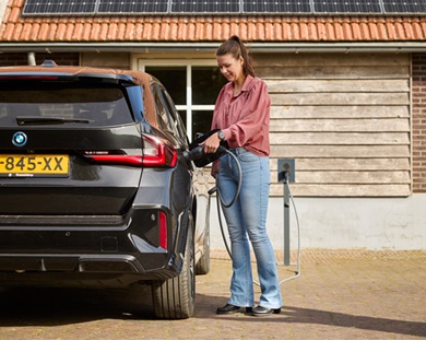 Vrouw plugt de stekker in haar elektrische auto