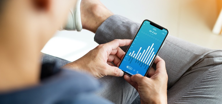 Man met telefoon in hand. ENGIE-app toont verbruiksgegevens.