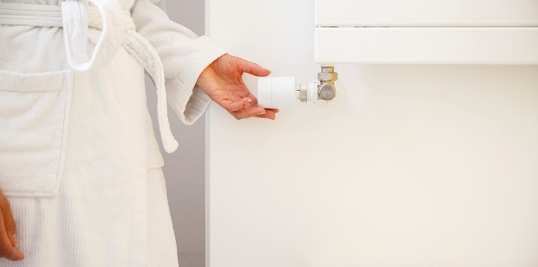Vrouw draait aan thermostaat