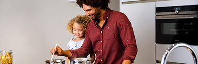 Man en kind staan in de keuken